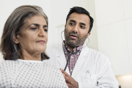 Lungenkrebs behandeln | Novartis - klinische Forschung - Arzt untersucht Patientin mittleren Alters