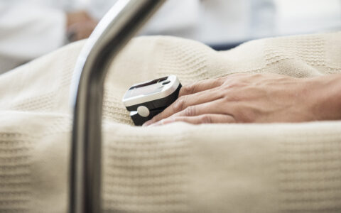 Biomarker Lungenkrebs | Novartis - klinische Forschung - Hand auf Krankenhausbett mit Pulsmesser