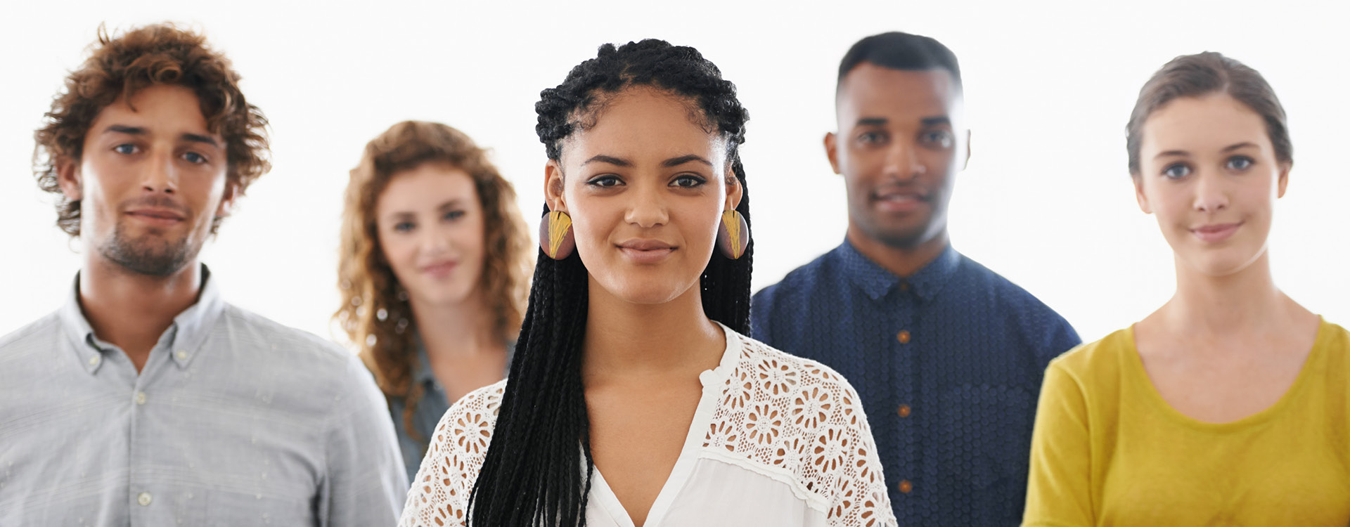 Gruppe mit fünf jungen Erwachsenen vor weißem Hintergrund, eine Frau mit geflochtenem Haar im Mittelpunkt.