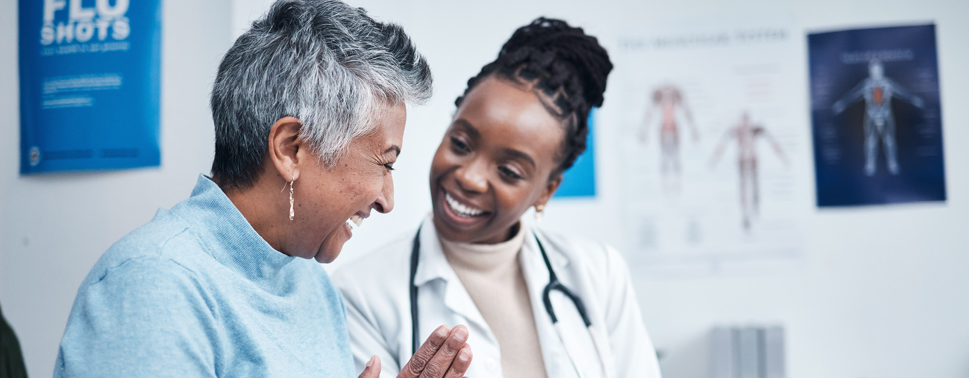 novartis-klinische-forschung-gut-informiert-gesundheitswissen-nicht-interventionelle-studien Eine Ärztin und eine ältere Frau lächeln sich in einem Behandlungszimmer an.