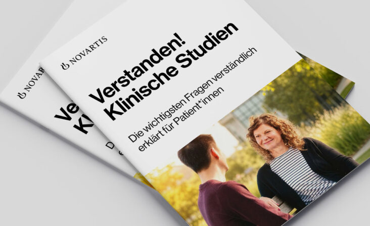 Zwei Exemplare der Broschüre "Verstanden! Klinische Forschung" auf grauem Hintergrund
