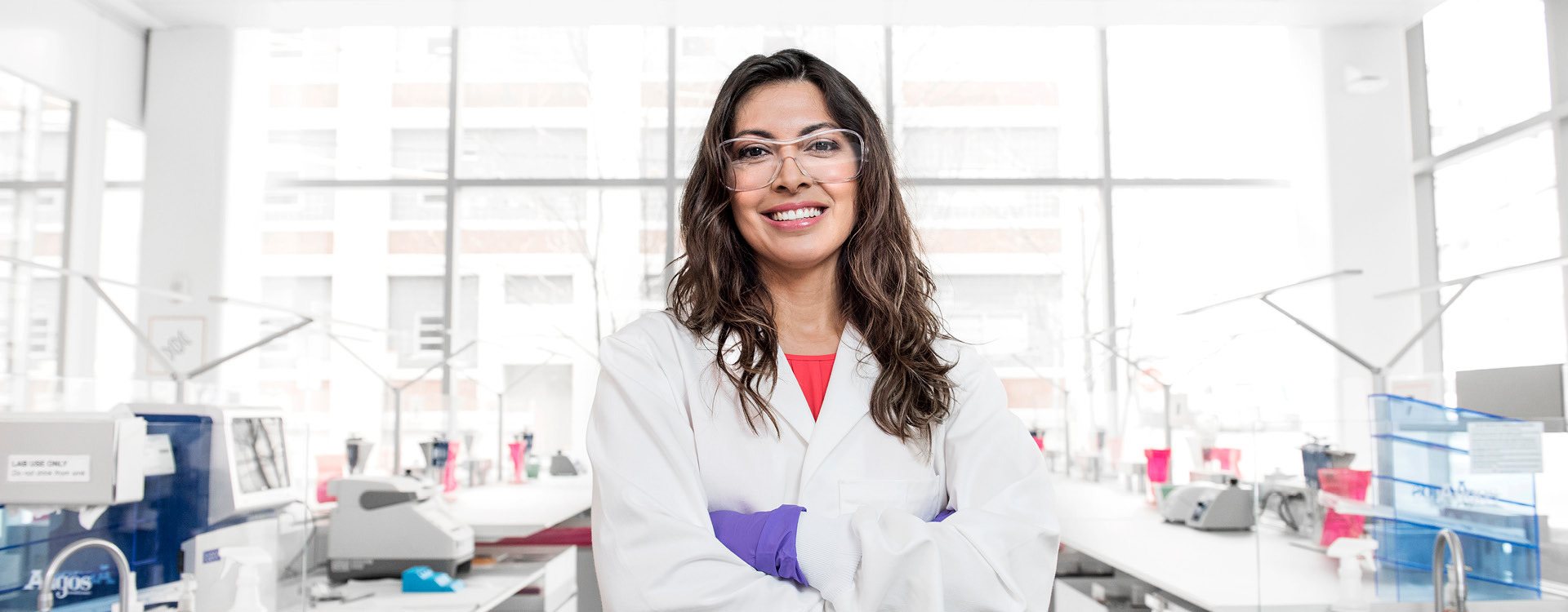 Frau mit Kittel und Schutzbrille | Novartis – Klinische Forschung