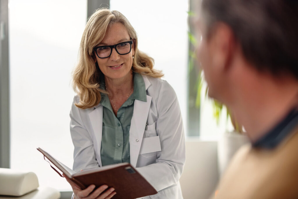 Female Doctor Discussing Illness with Her Male Patient in The Office